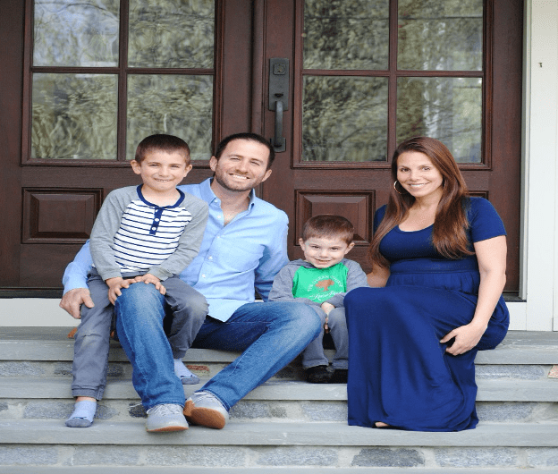 Dr. Markowitz and his family posing on the front steps of a house