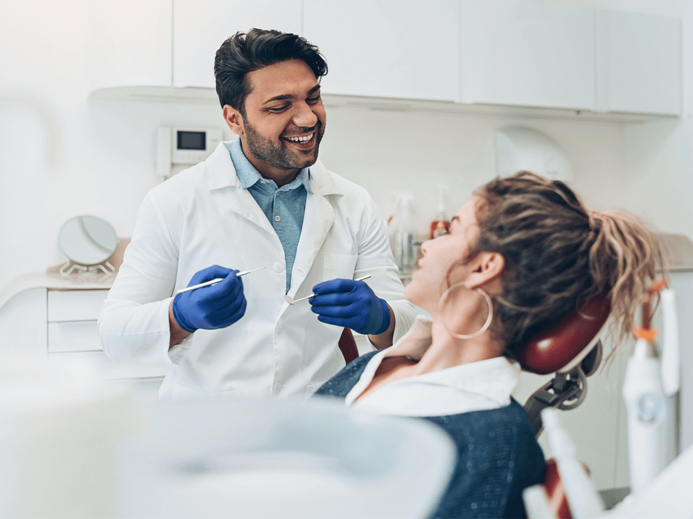 Dentist and young patient smiling.